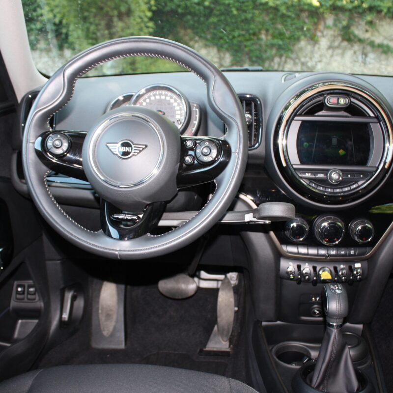 Interno auto Mini con volante, cruscotto e cambio.